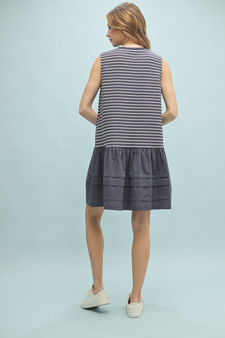 Back view of sleeveless navy and white striped drop waist dress with gathered skirt