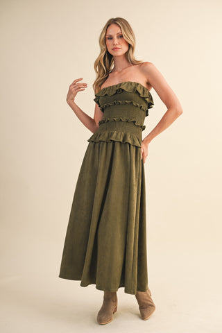 Woman wearing a green strapless dress on a beige background