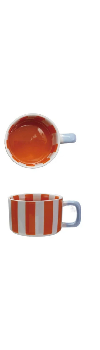 Hand-painted stoneware mug with bold orange stripes and a powder blue handle. A cheerful, artisanal piece perfect for coffee, tea, or display. Microwave- and dishwasher-safe.