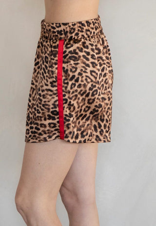 Leopard print skirt with a red stripe on a plain background