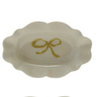 Four small ceramic dishes with colorful bow designs on a white background